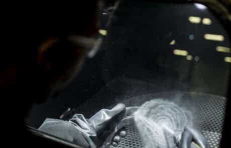 Worker finsihing a metal piece