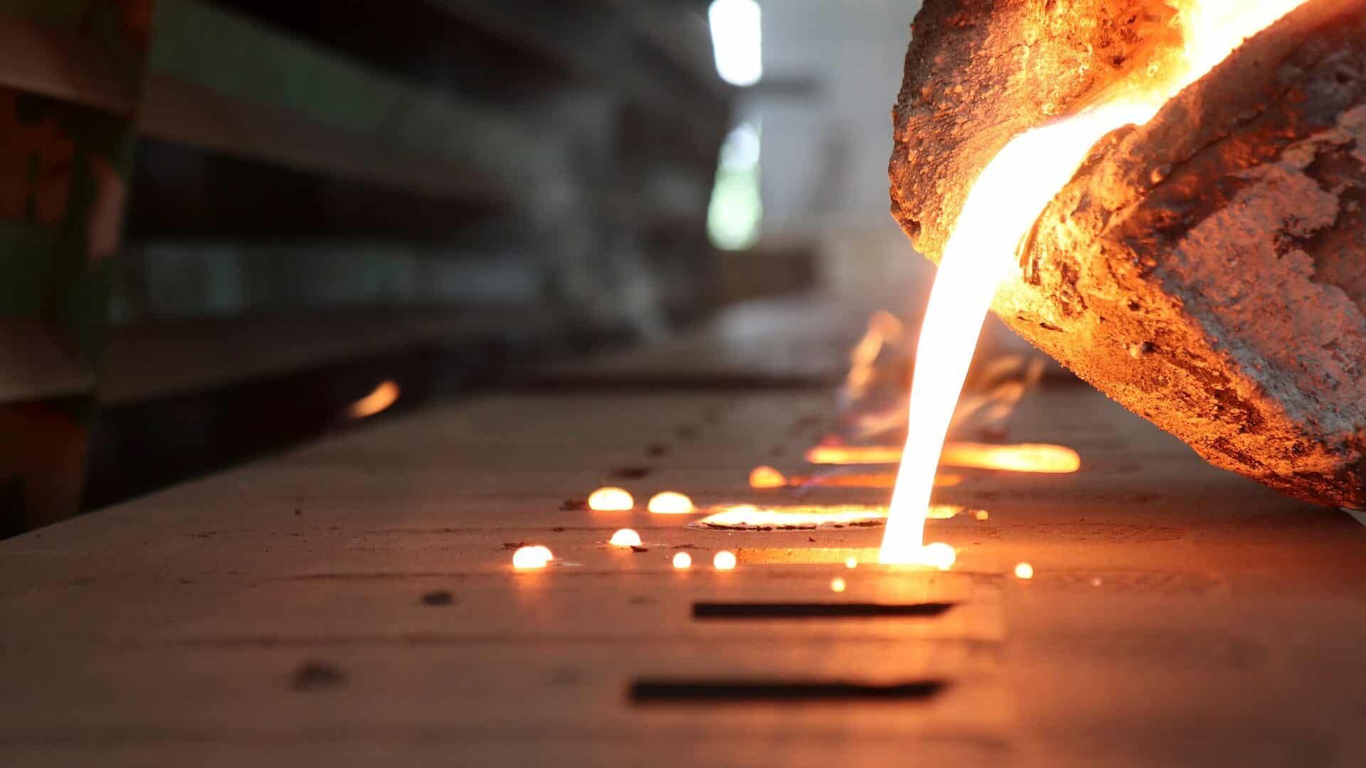 Light,From,High,Temperature,Iron,Molten,Metal,Pouring,In,Green Molten material being poured into a mold