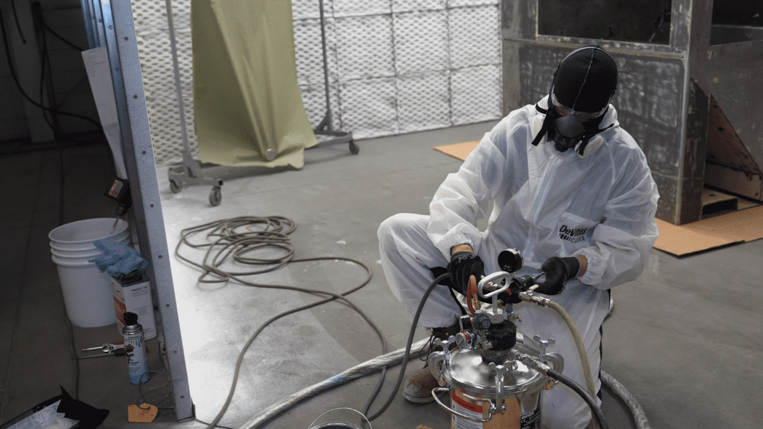 Calibrating pressure valve in paint pot specialist calibrating pressure valve in a paint pot in full ppe