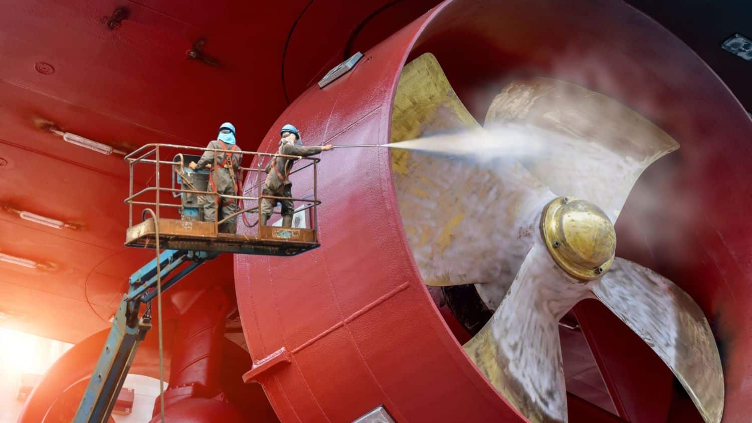 Two specialists blasting a large wind turbine