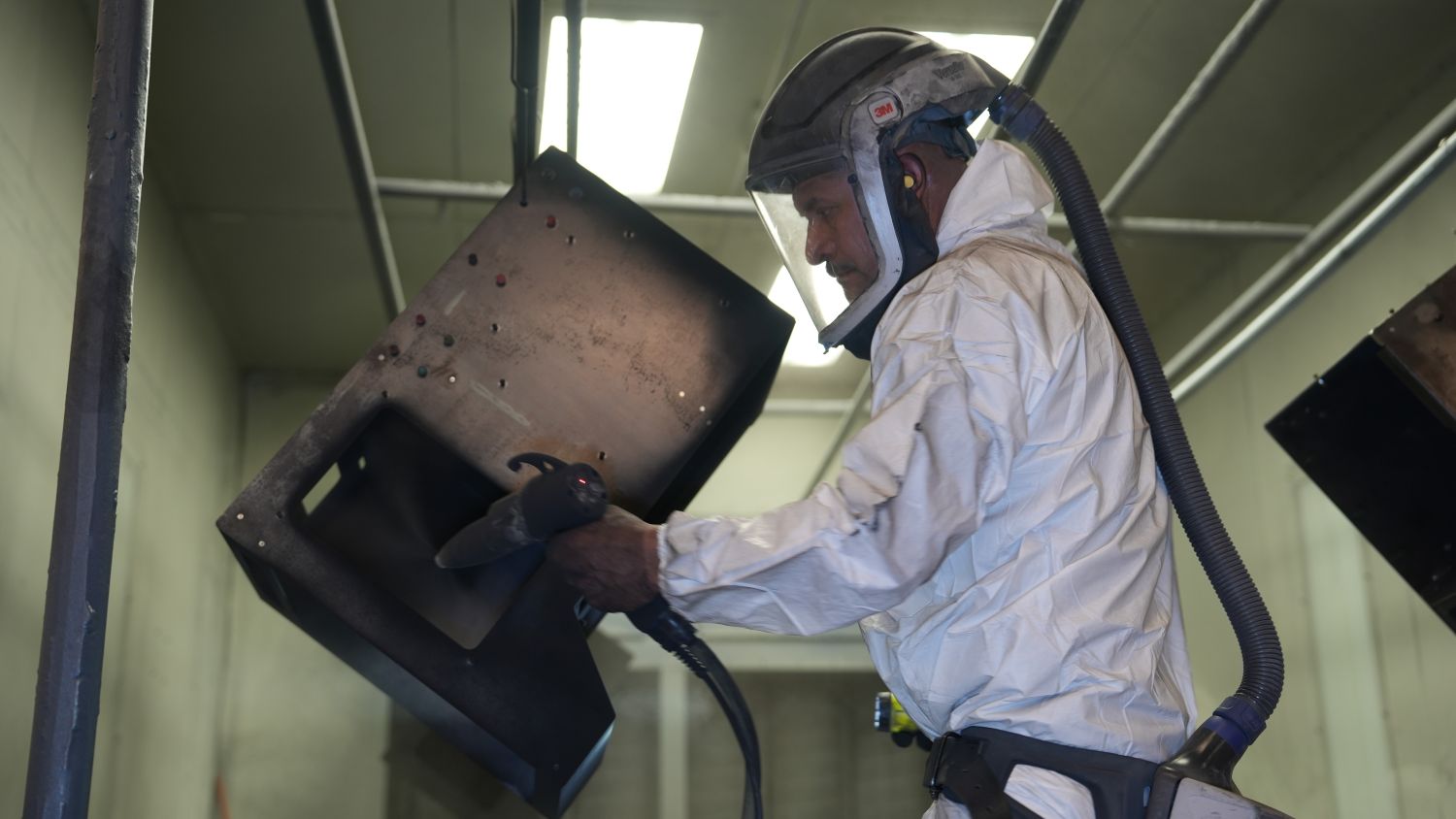 StartUpServices A worker in ppe setting up a part to be painted