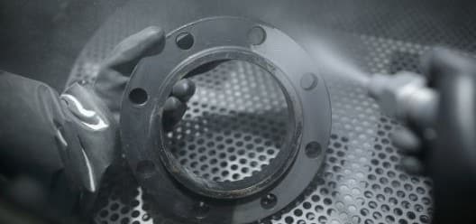 HAM_5161 A metal part being finished in a hand air blast cabinet